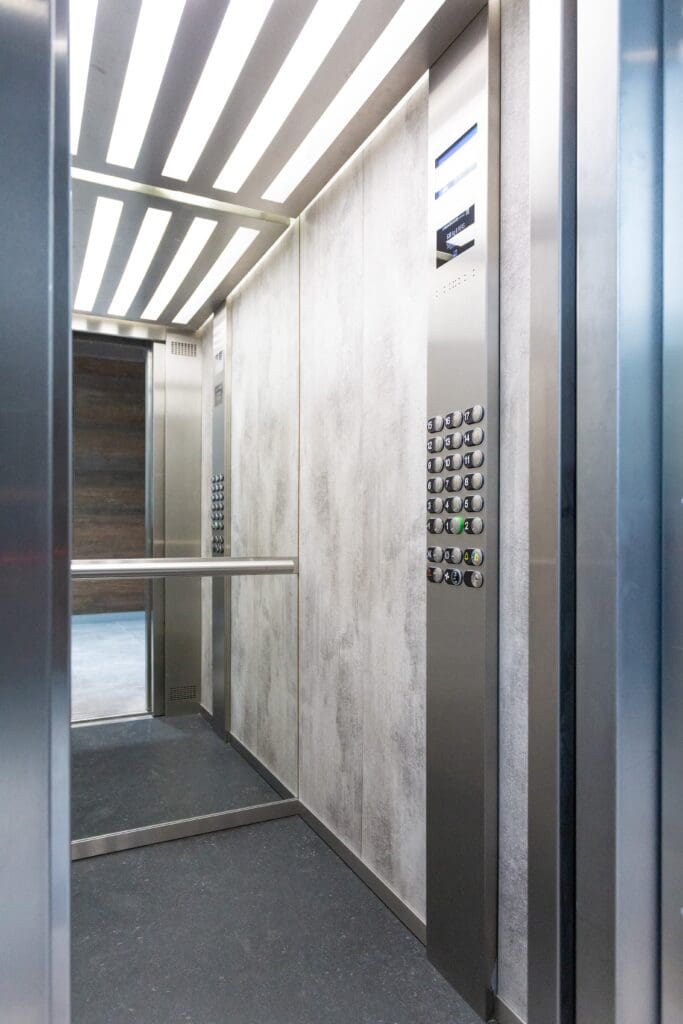 Industrial grey elevator with mirror on other side of door