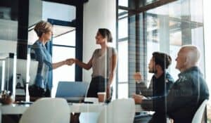 Business women greeted to meeting with handshake in meeting room