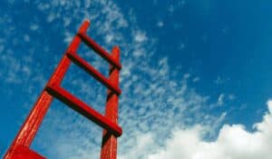 a red ladder extending to a blue sky