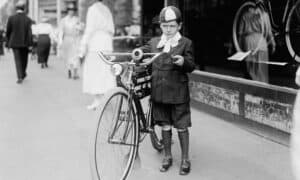 black and white photo of a child with a bike