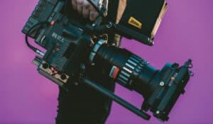 camera in front of a purple background