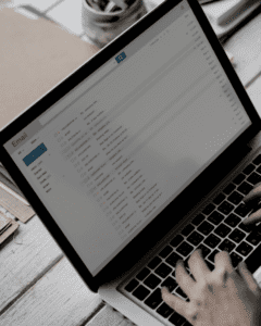 Hands on a laptop keyboard while the screen shows an email inbox