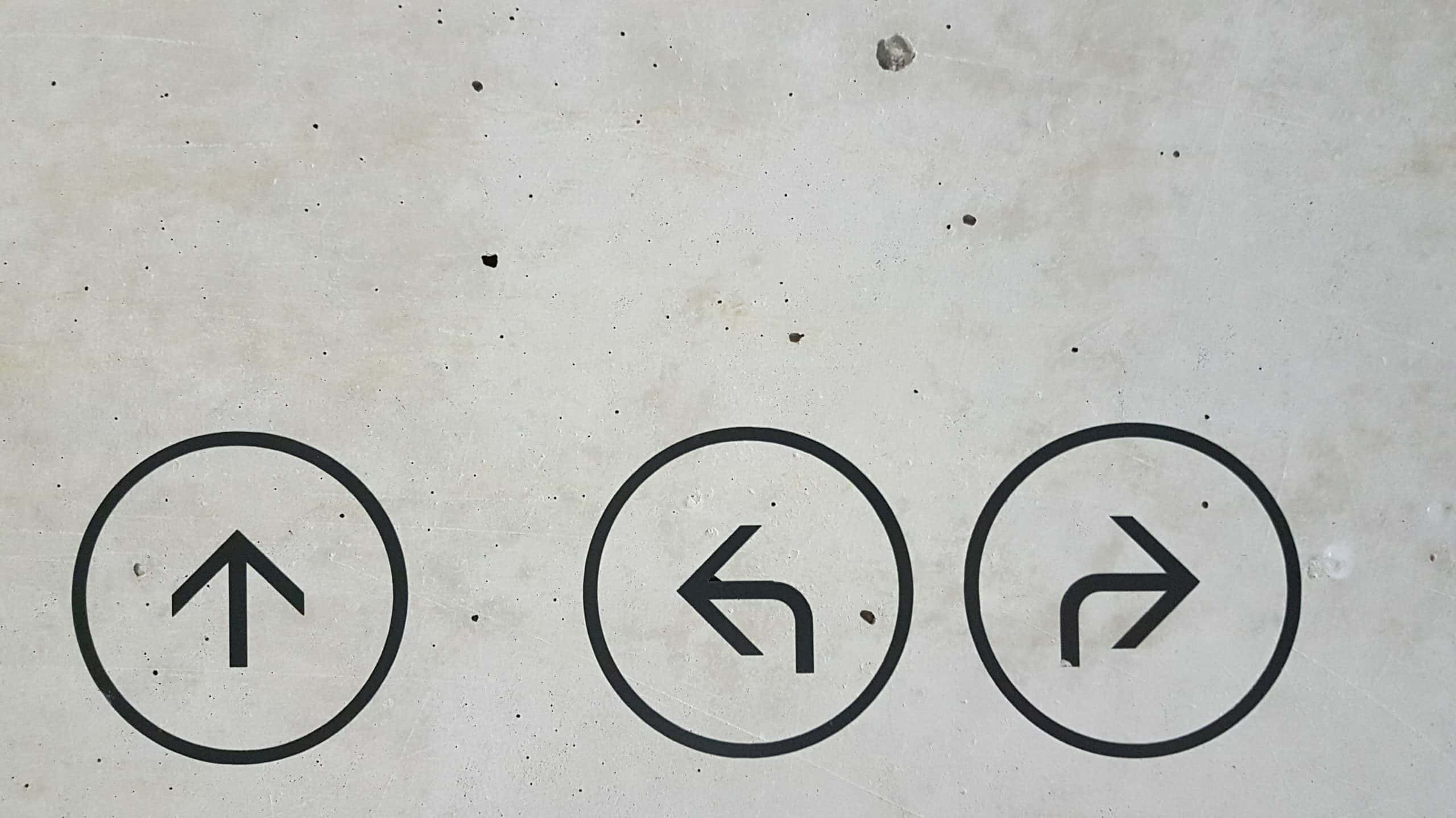 Image of 3 arrows pointing different directions on concrete for landing page blog