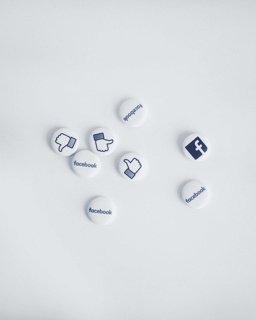 Facebook name, logo, and "like" buttons on a white surface.