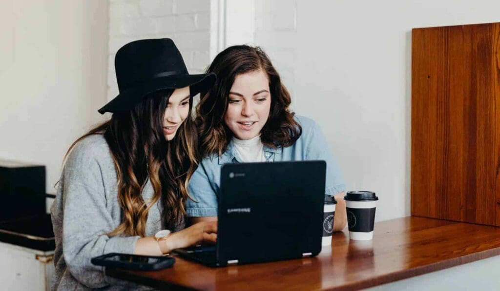 girls laughing around a computer