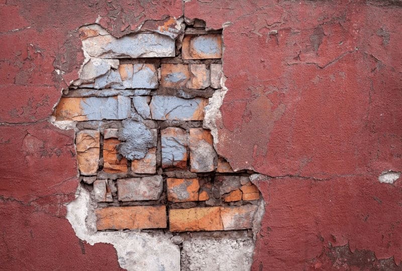 exposed brick wall under a smoother red one