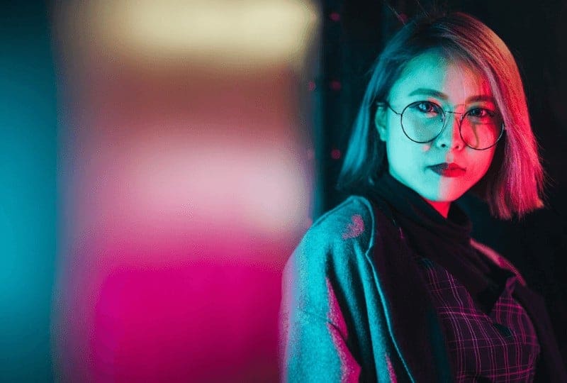 blue and pink lights on a girl in glasses