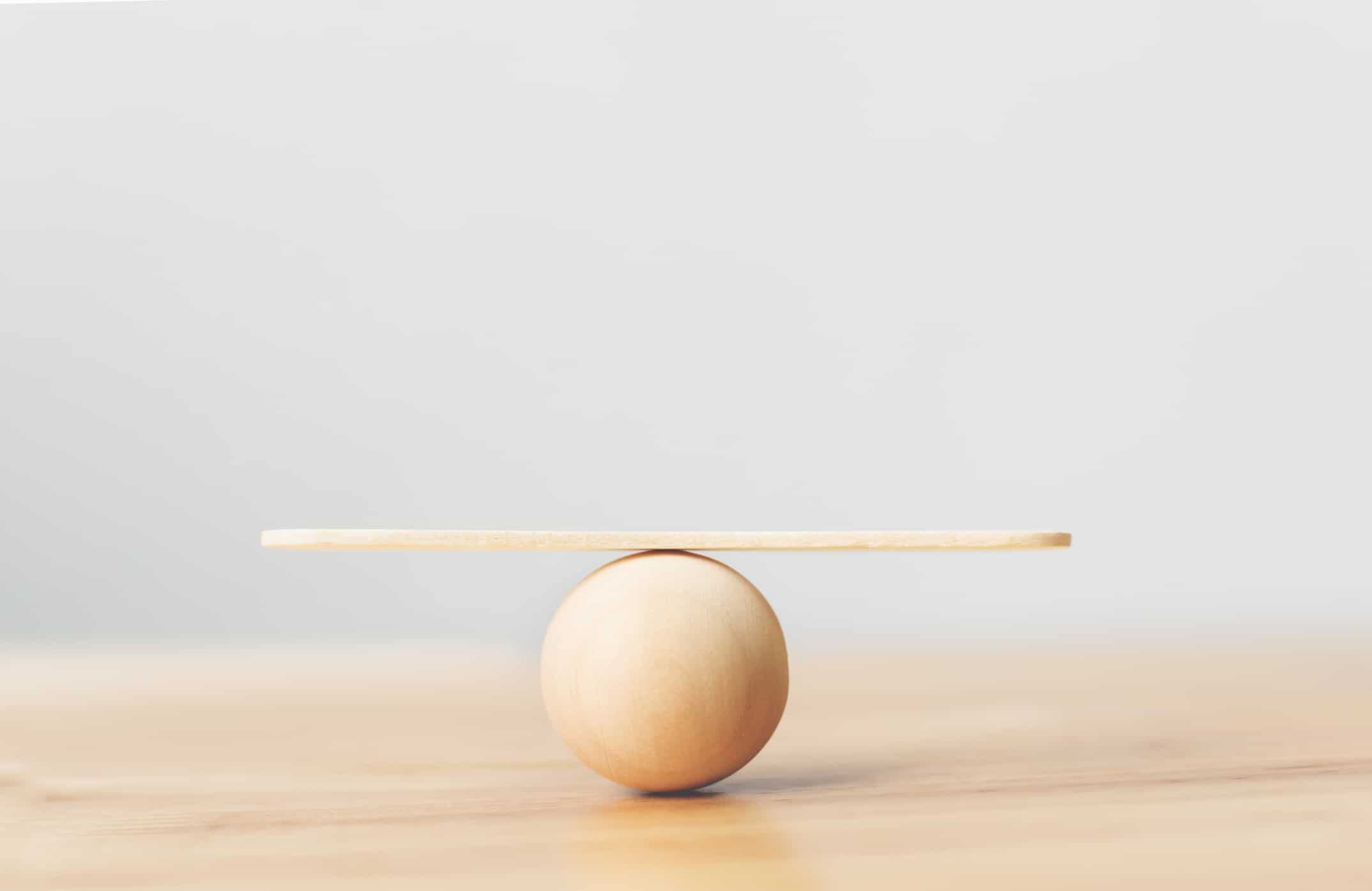 Wooden ball balancing a wooden stick on top