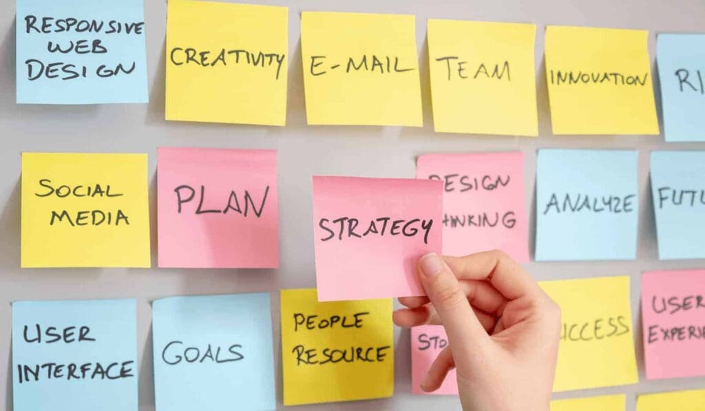 sticky notes on whiteboard that say "strategy" "plan" "creativity" "goals"