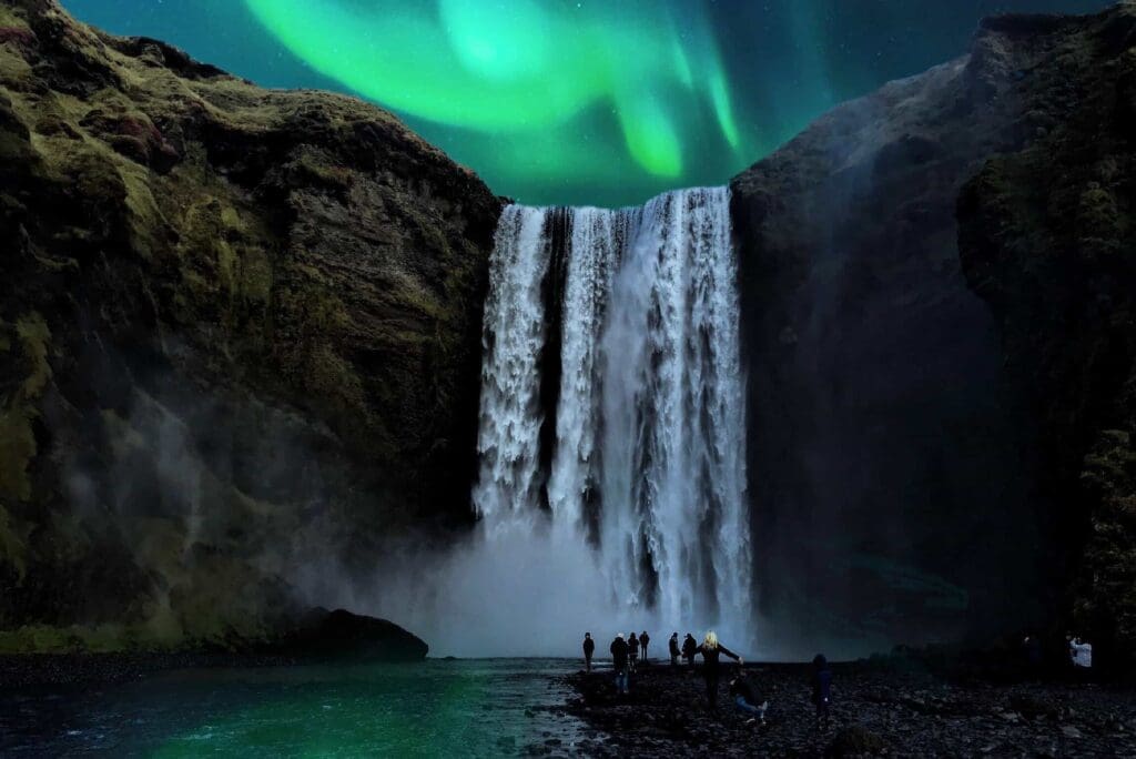 image of a waterfall and distant people walking towards it, night sky light by green streaks