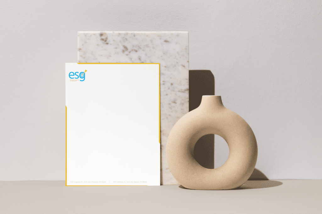 ESG letterhead in front of marble and next to a ring shaped vase