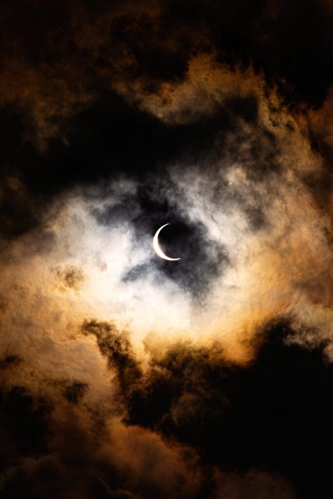 Spooky marketing mistakes image of crescent moon against black and orange tinted clouds.