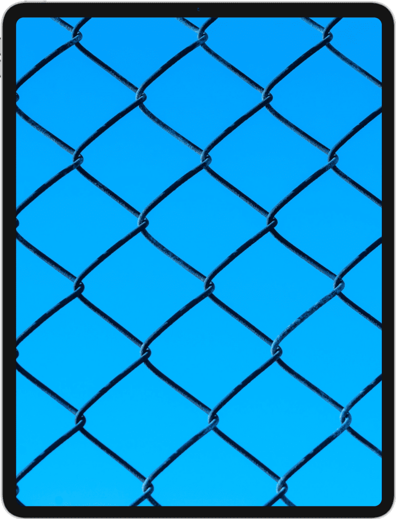 iPad featuring a black chain link fence in front of a blue sky