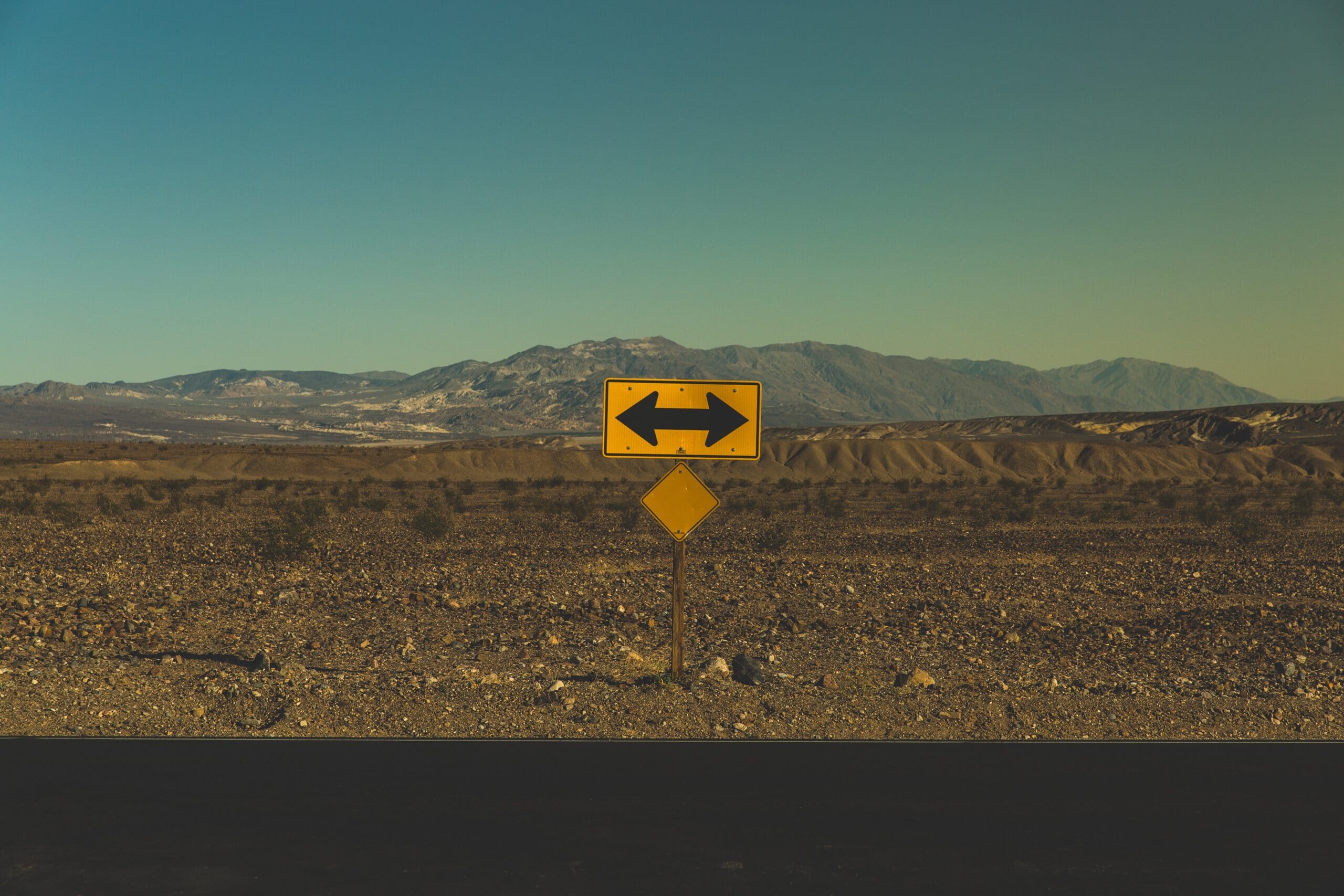 Double sided arrow sign in a desert
