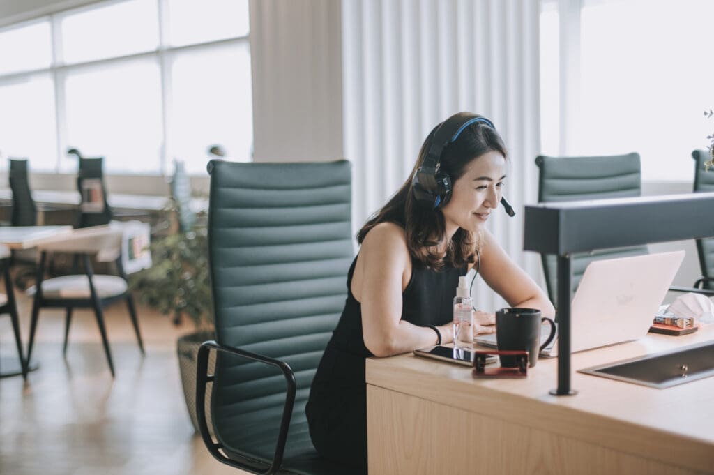 Woman wearing headphones at an office desk